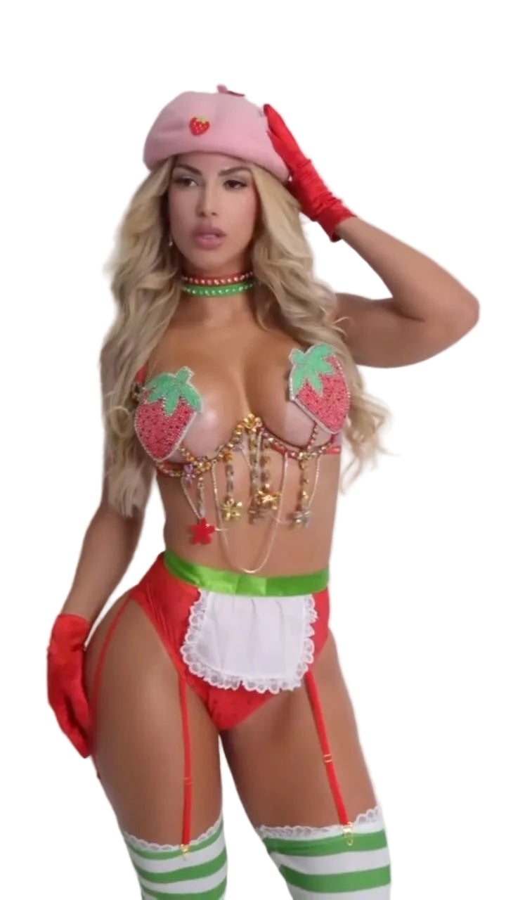 A woman modeling a strawberry-themed lingerie costume against a plain light gray background. The outfit includes a pink beret with a strawberry detail, red gloves, a red and white mini skirt with a white apron overlay, strawberry bra cups with green leaf accents, red and white striped thigh-high stockings, and a green beaded choker.